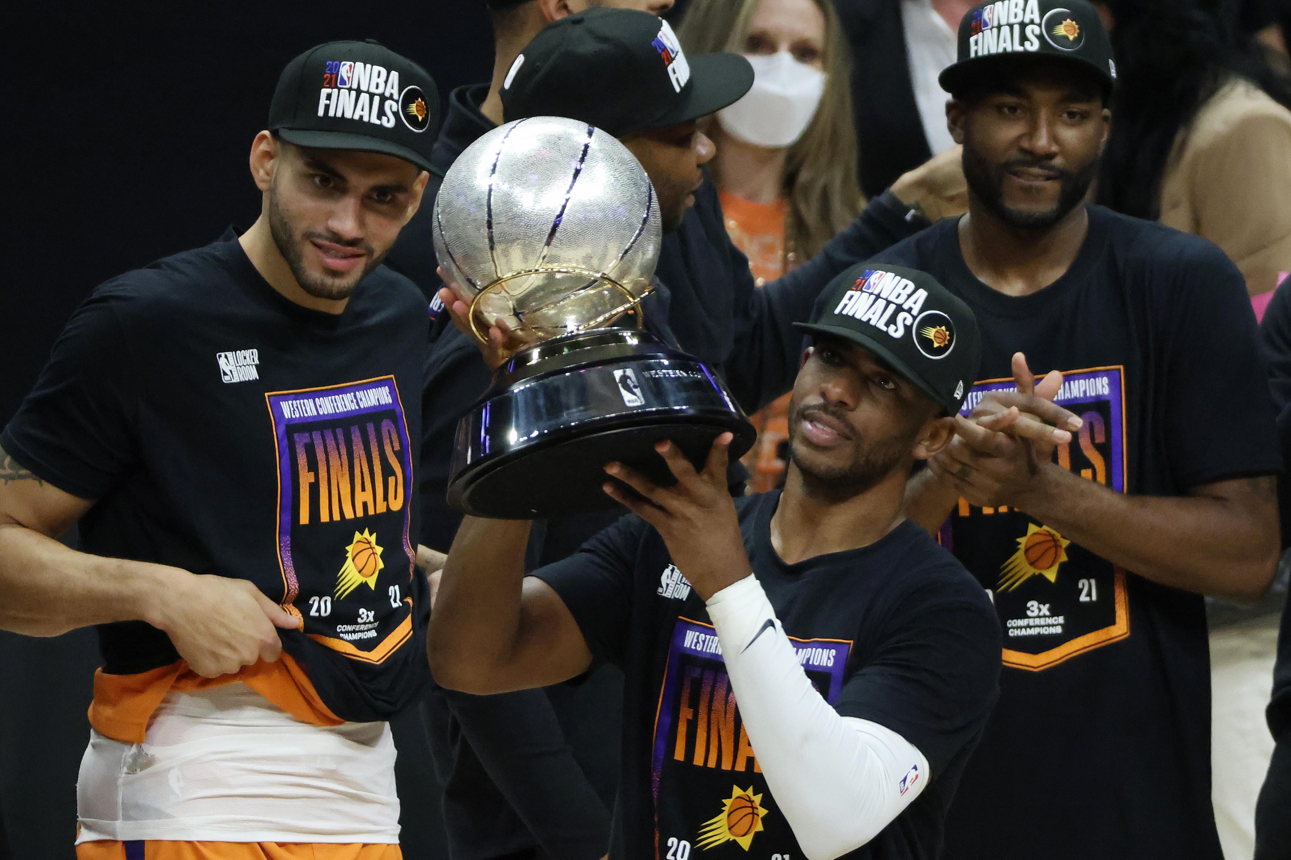 Chris Paul holds up the Western Conference championship trophy as he stands among his Suns teammates after they won Game 6