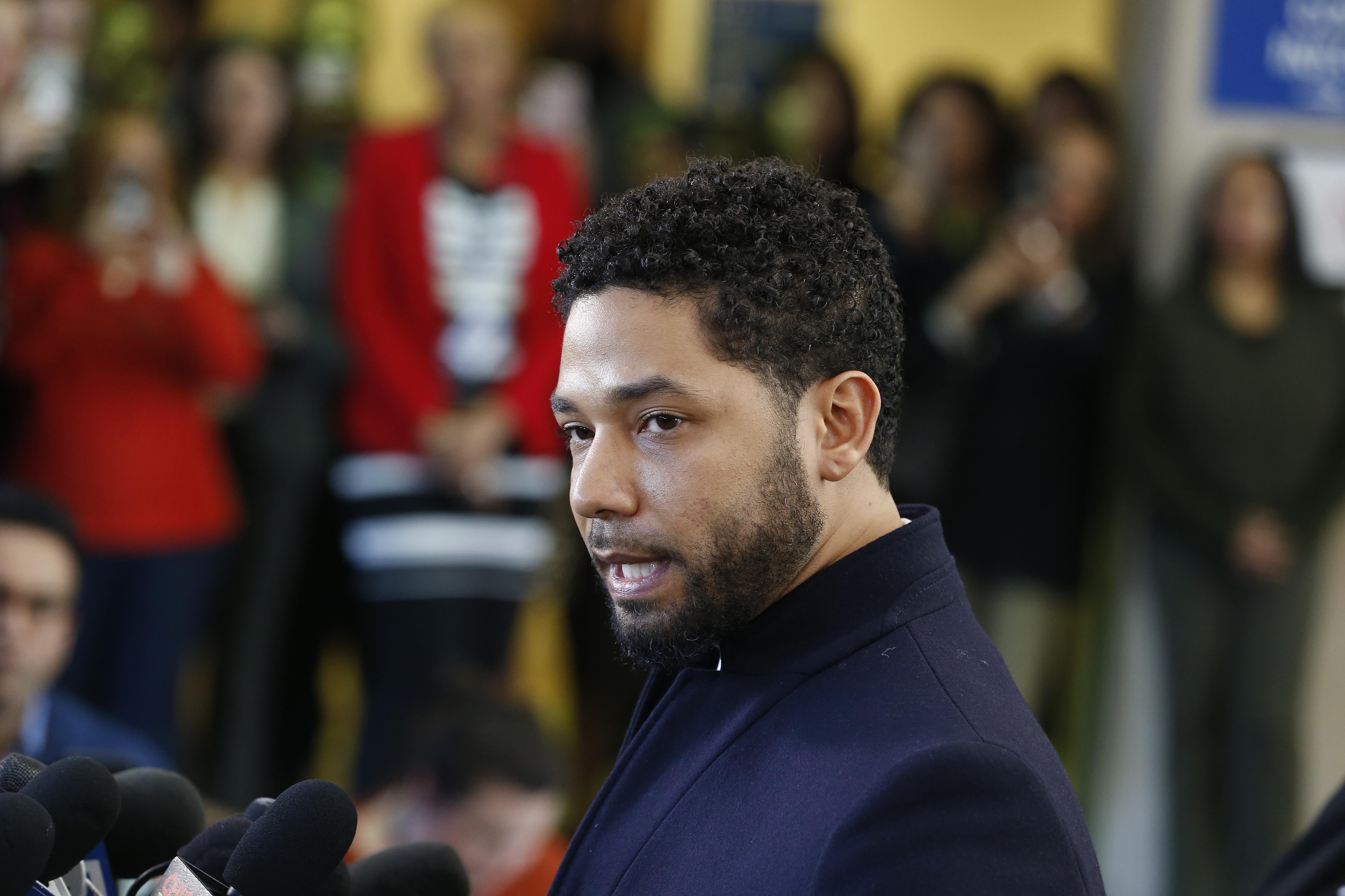 Actor Jussie Smollett stands in front of a microphone at a press conference.