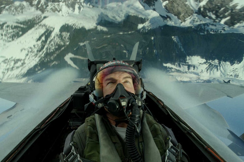 Cruise sits in a cockpit, in his classic "Maverick" helmet, straining against the Gs, possibly inverted