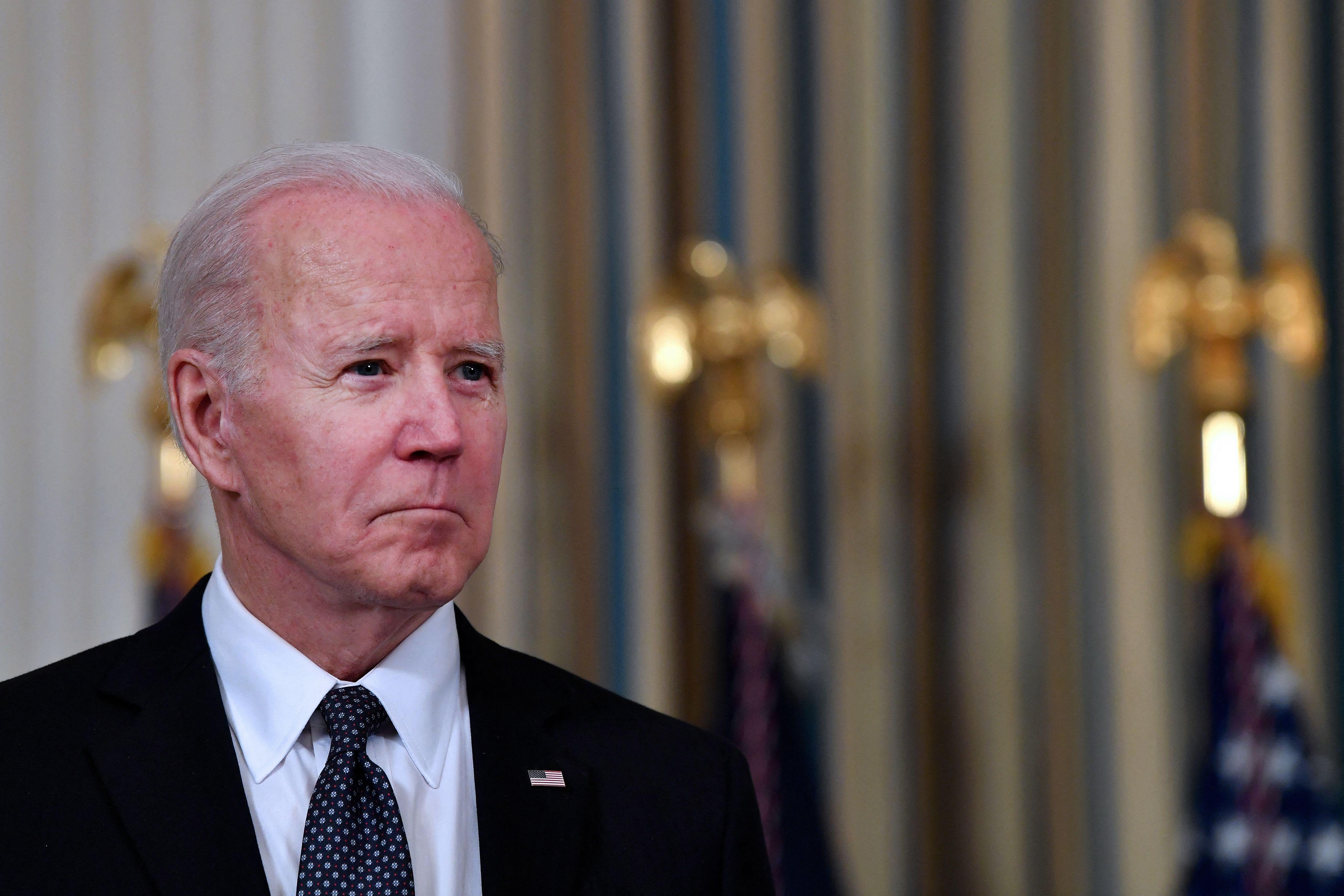 Biden looking sheepish in the state dining room of the White House