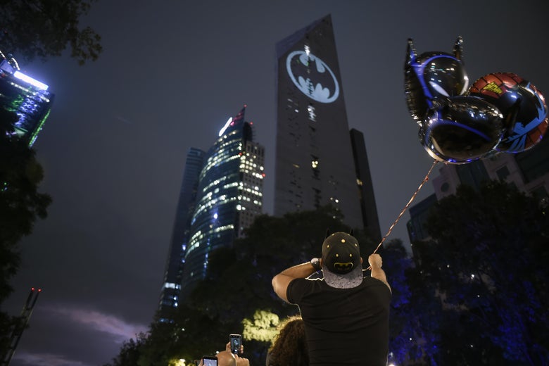 A bat signal projected on the side of a Mexico City skyscraper.
