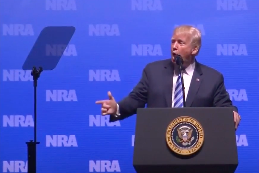 Donald Trump uses his hand to mimic a gun during his speech at the National Rifle Association convention in Dallas, Texas on May 4, 2018. 