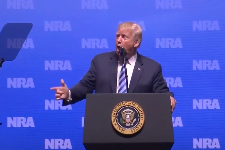 Donald Trump uses his hand to mimic a gun during his speech at the National Rifle Association convention in Dallas, Texas on May 4, 2018. 