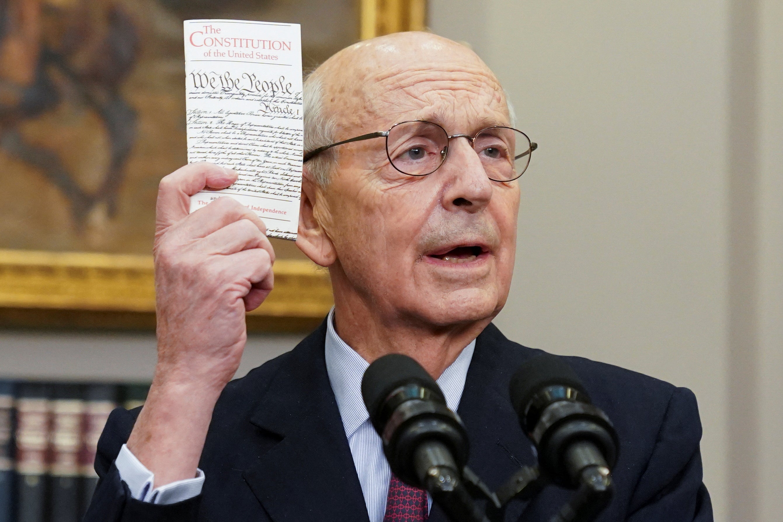 U.S. Supreme Court Justice Stephen Breyer holds up a copy of the U.S. Constitution as Breyer announces he will retire at the end of the court's current term.