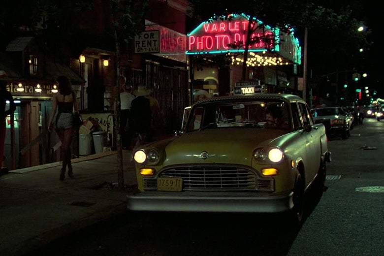 A still from Taxi Driver, showing a yellow cab pulling up in front of a neon storefront.