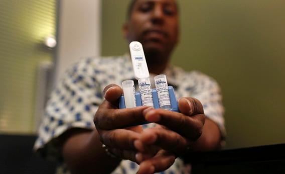 A staff member at the AIDS Service Center of New York City (ASC/NYC) holds an OraQuick Advance Rapid HIV-1/2 Antibody test kit.