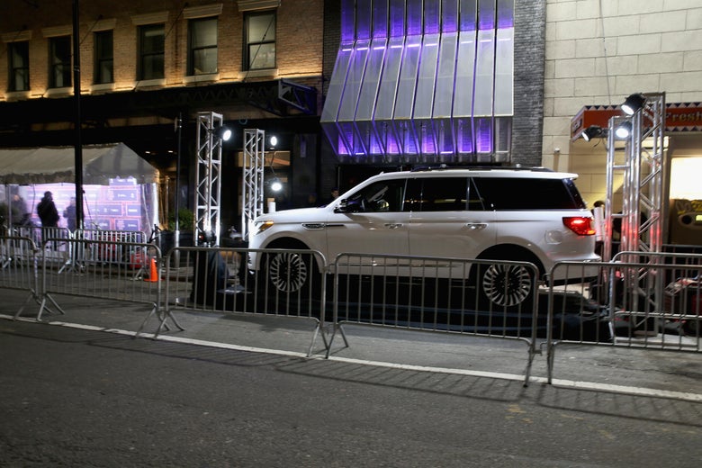 A Lincoln Navigator outside the venue, behind steel crowd control barriers.
