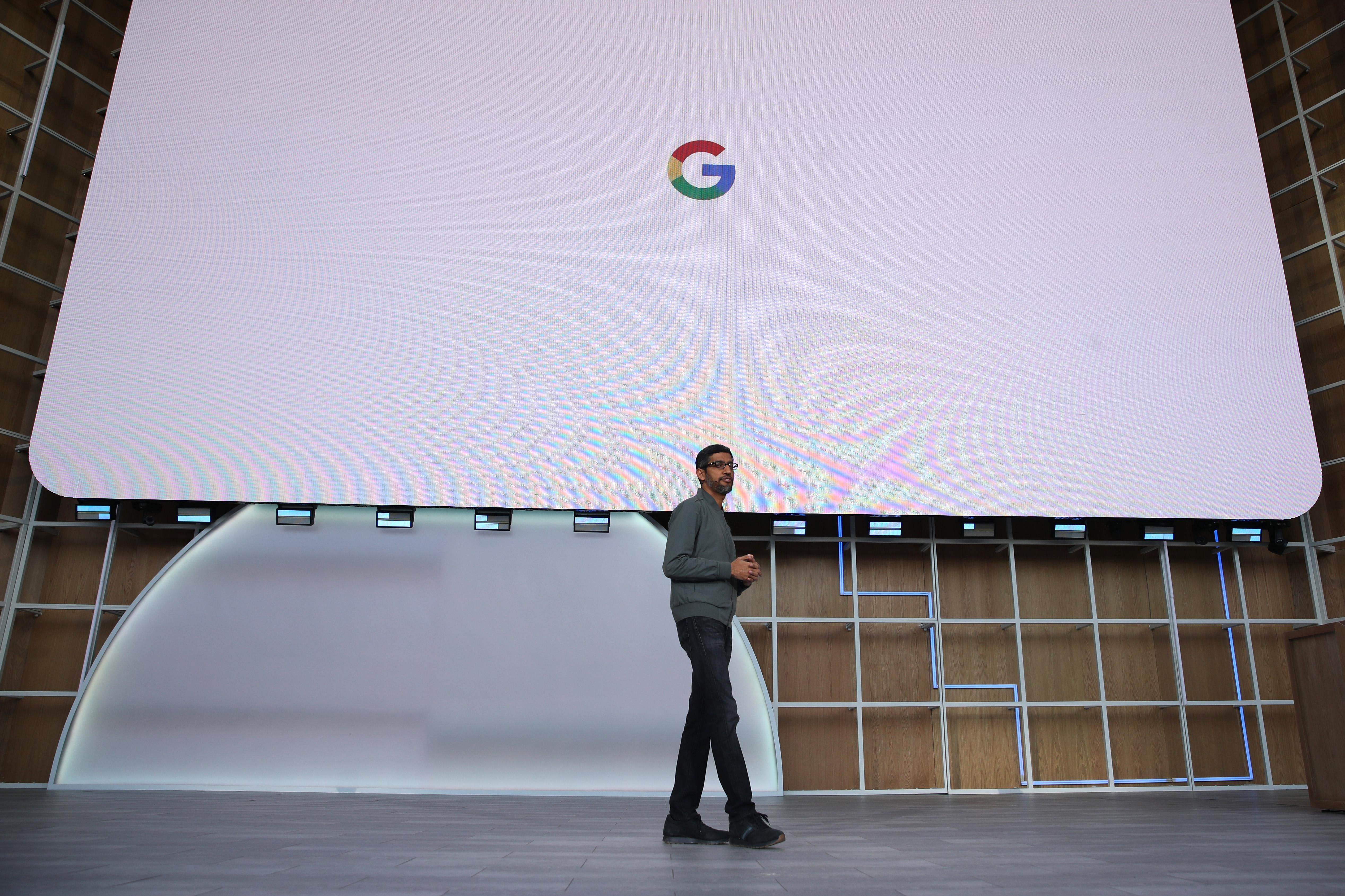 Sundar Pichai onstage in front of a huge screen displaying the Google logo.