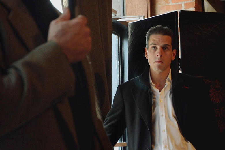 Hunter Biden stands in the background as Joe Biden holds a microphone