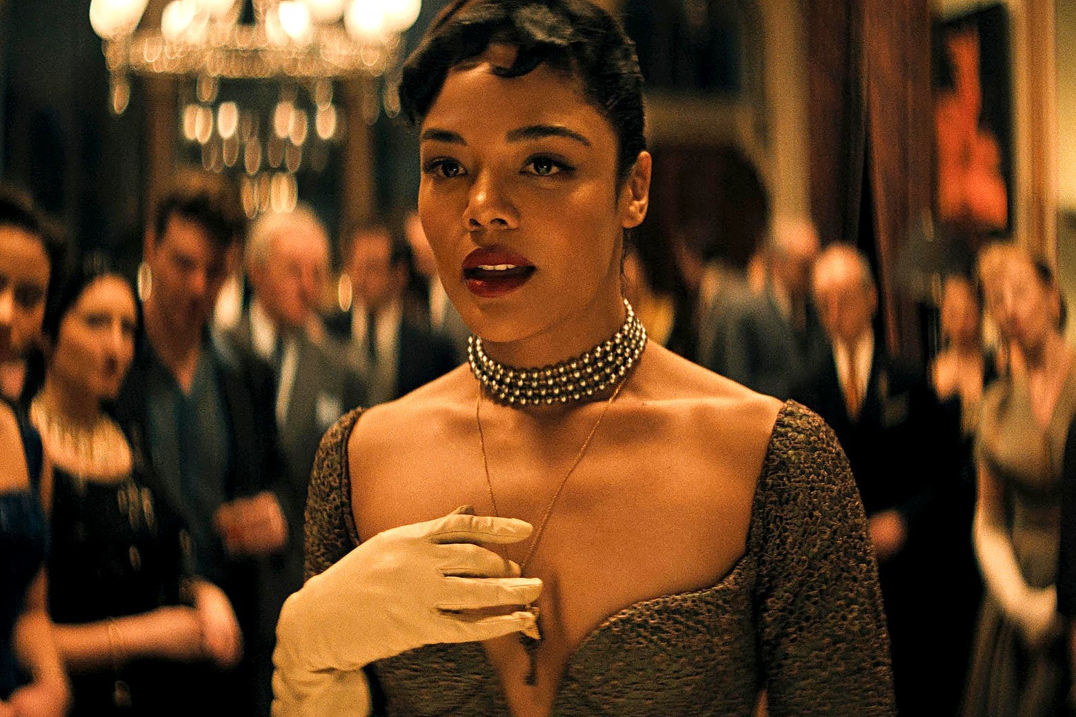 Tessa Thompson as Hedda, dressed in finery at a party.