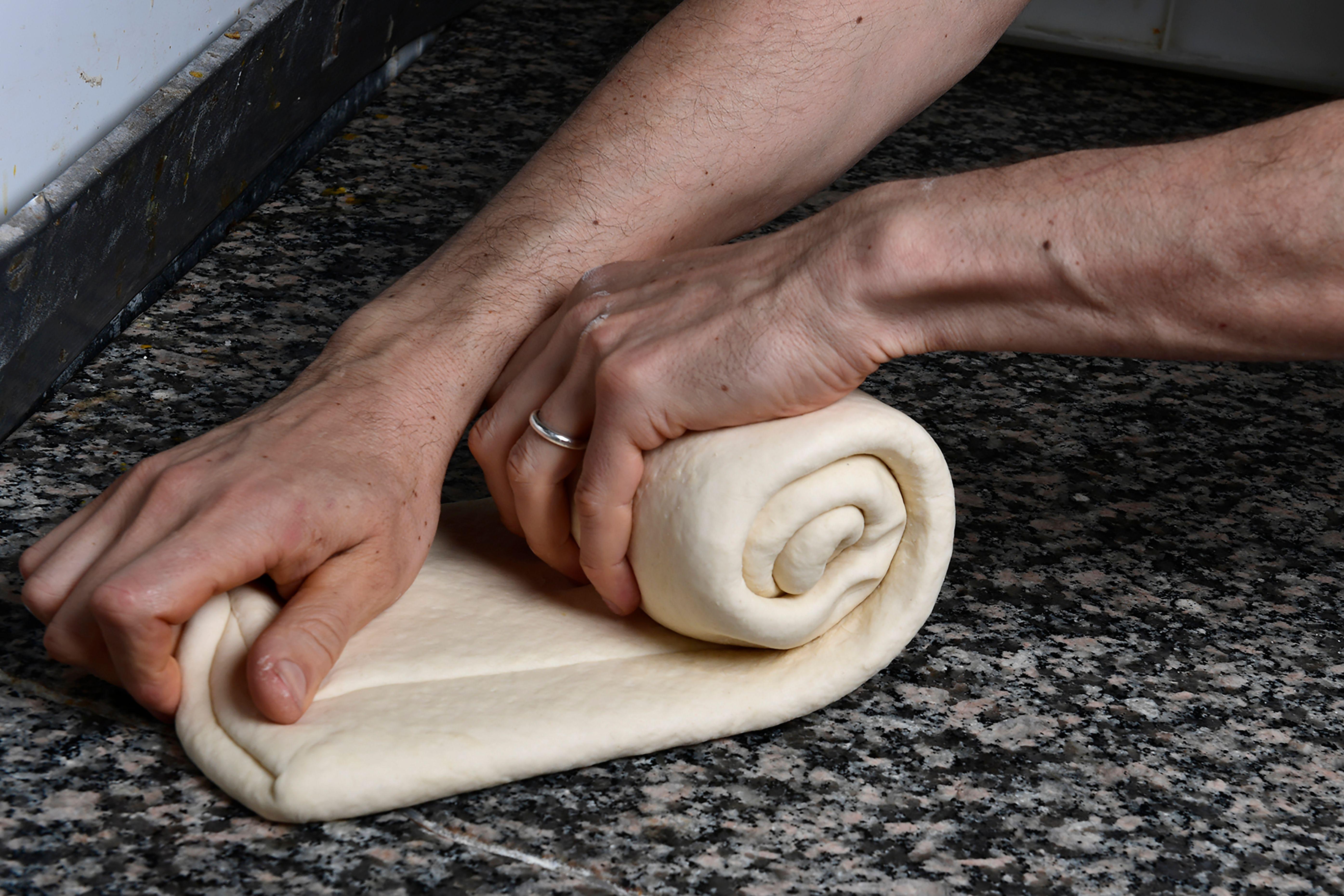 A pastry chef rolls the dough during the making of a traditional Christmas sweetbread 'Panettone' on December 6, 2017 at the Pasticceria San Gregorio in Milan.