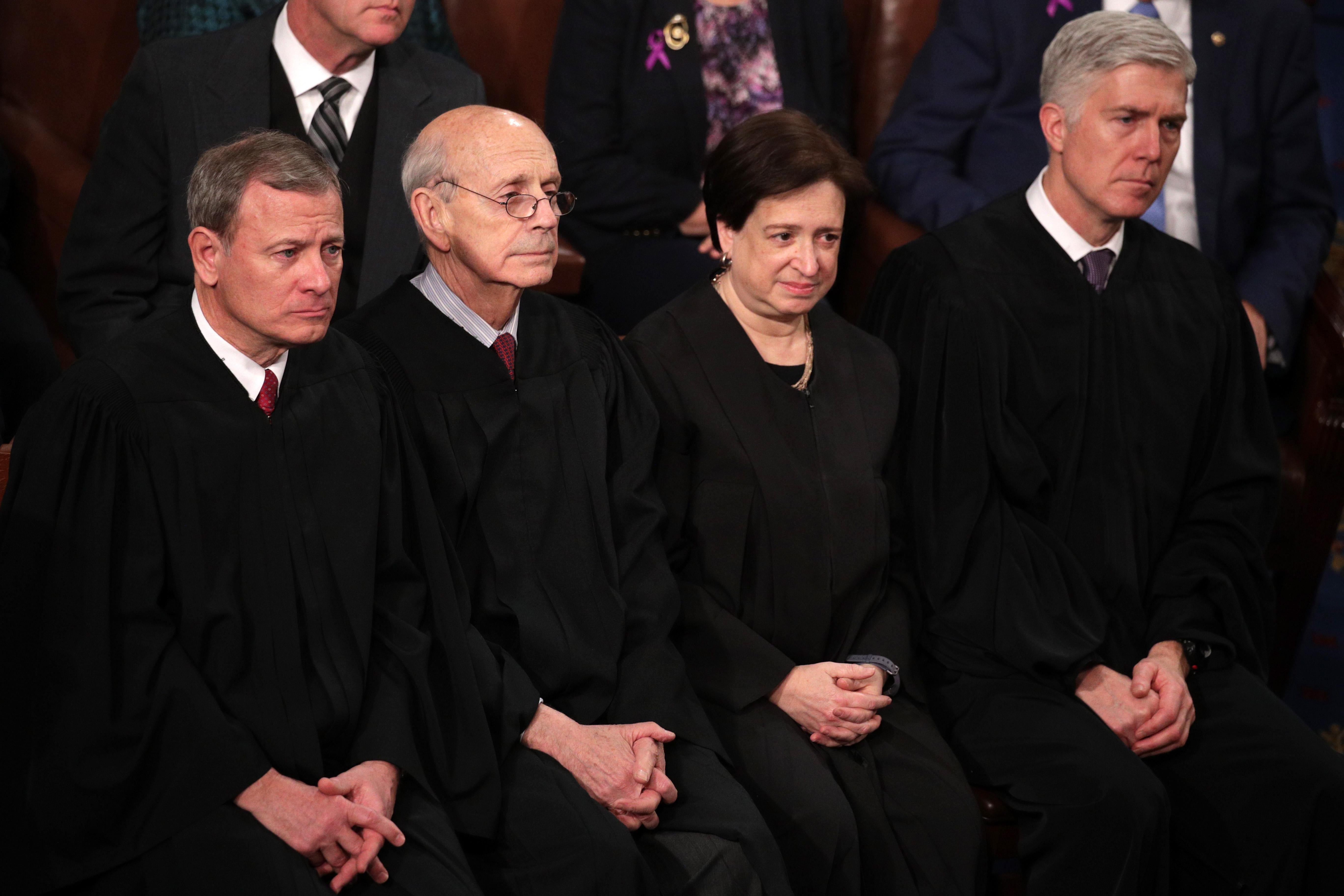 The four justices seated, wearing black robes.
