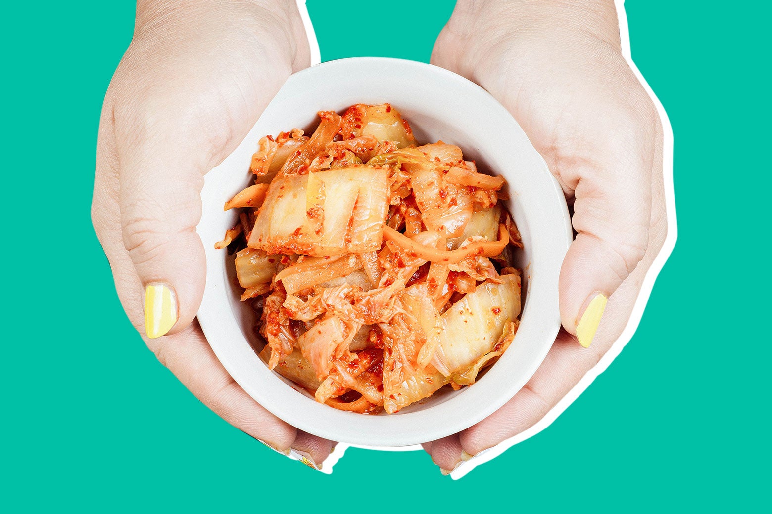 Photo illustration: A woman holds a bowl of kimchi.