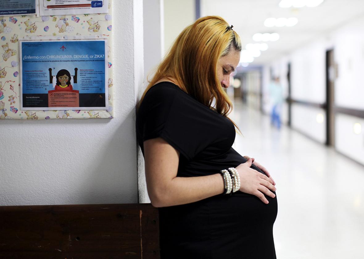 Jannelissa Santana, who is 37 weeks pregnant, leans on a wall, next to a flyer explaining how to prevent Zika, Dengue and Chikungunya viruses at a public hospital in San Juan, Puerto Rico, February 3, 2016. 