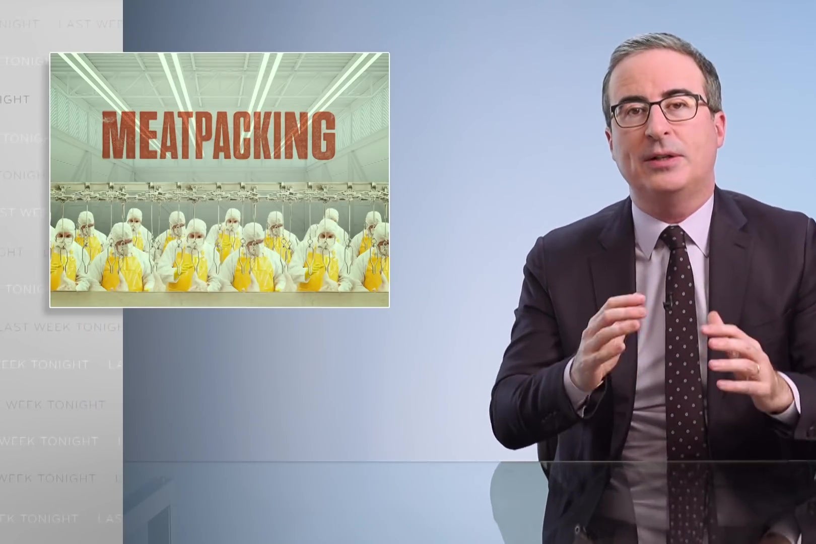 John Oliver sits behind a glass-topped anchorman desk; a graphic reading "MEATPACKING" is displayed behind him.