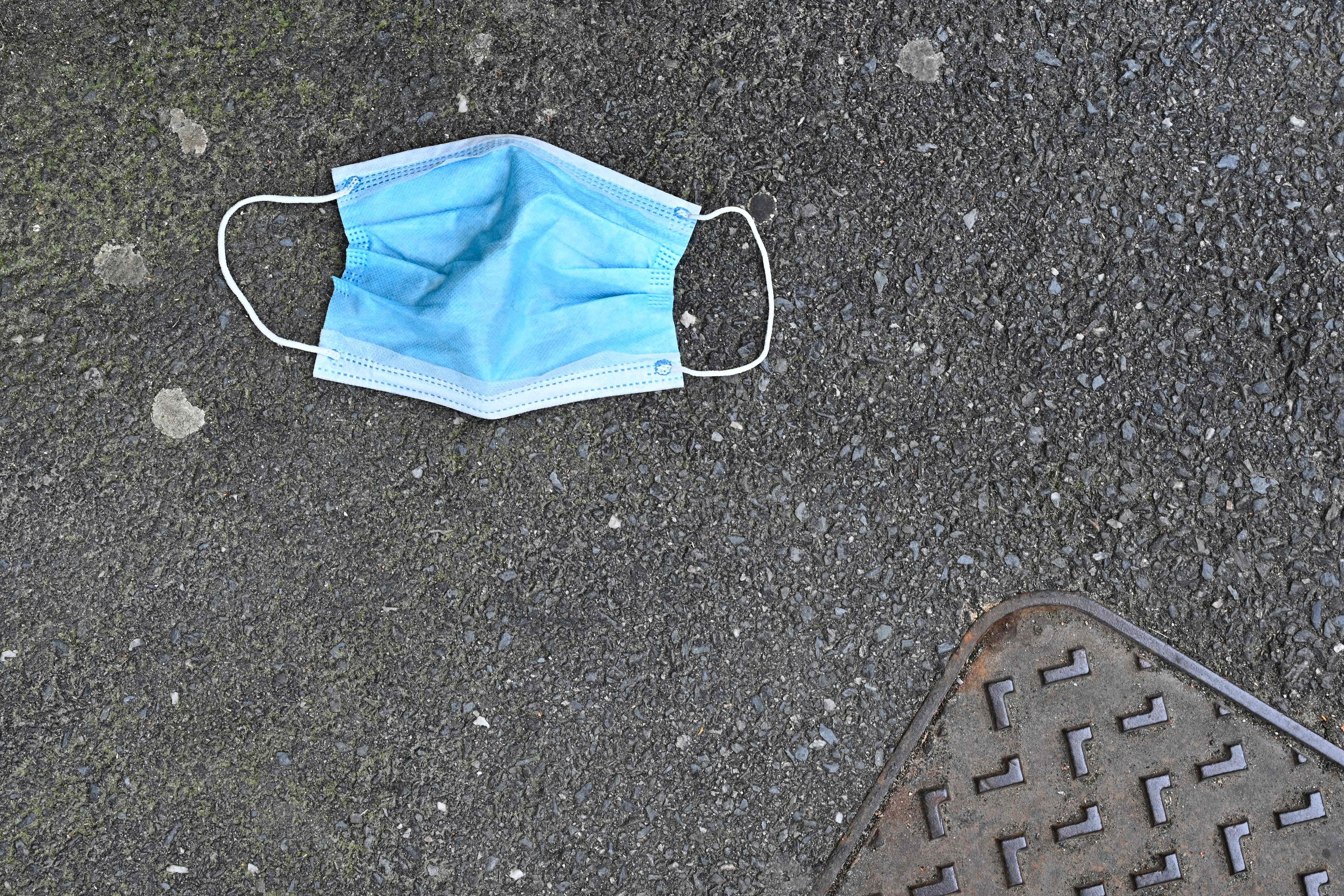 A protective face mask thrown in the street.