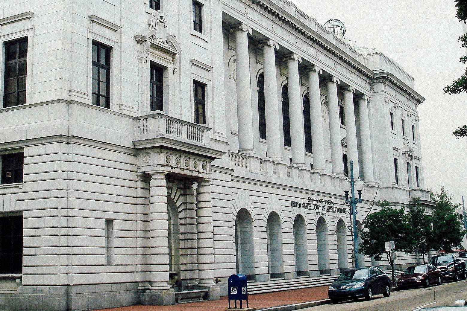 The outside of a gray courthouse building with tall columns.