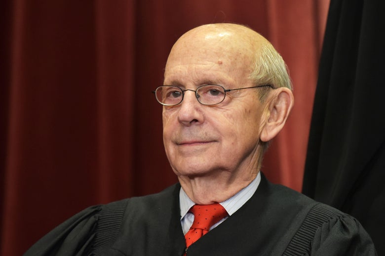 Stephen Breyer seated in a red tie and his Supreme Court justice robes