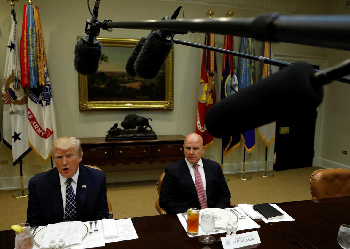 President Donald Trump, seated with U.S. National Security Adviser H.R. McMaster