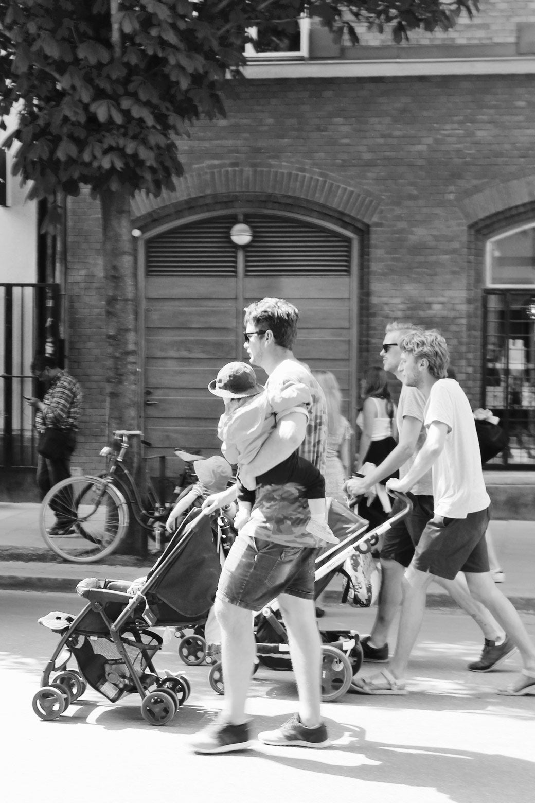 Three latte-pappor, or “latte dads”—the Swedish colloquial equivalent of “soccer moms”—stroll the streets of Södermalm together on a sunny weekday afternoon.