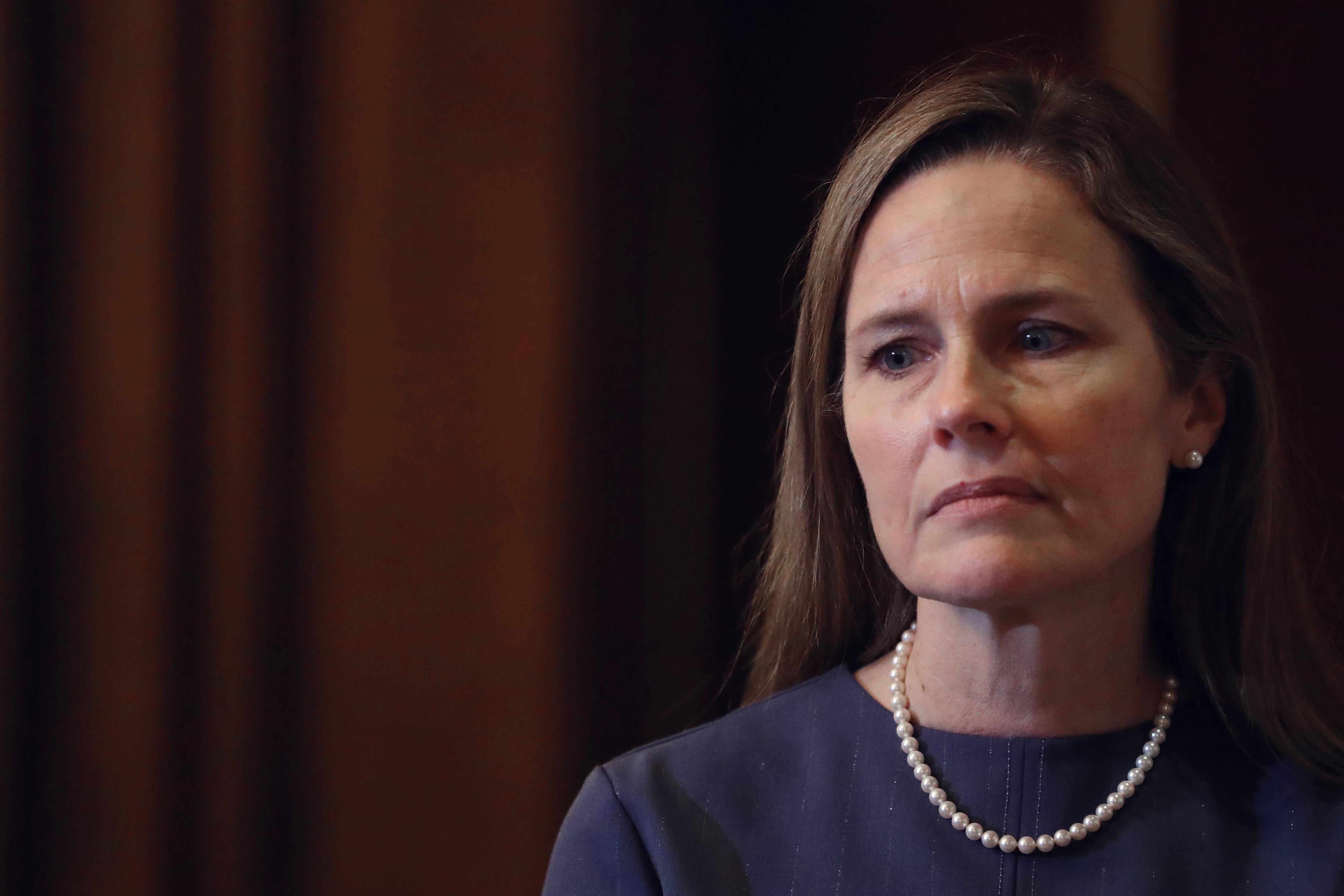 Amy Coney Barrett looks off to the side.