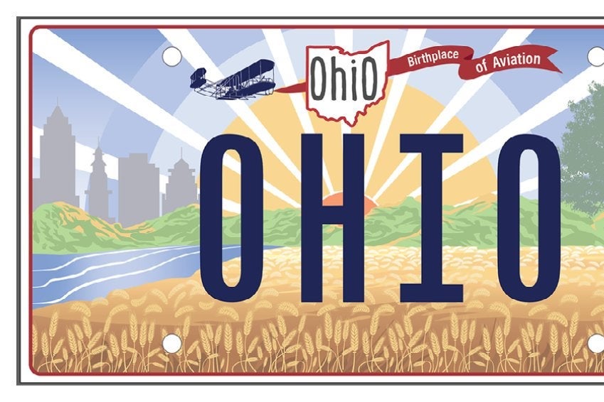 Ohio license plate featuring a field of wheat; a banner that says "Birthplace of Aviation" being pushed, not pulled, by an old plane; and the word OHIO where the license plate number would be