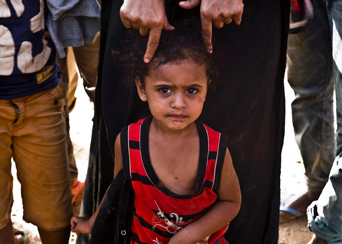 A child at the port awaits docking onto the boat to Yemen.