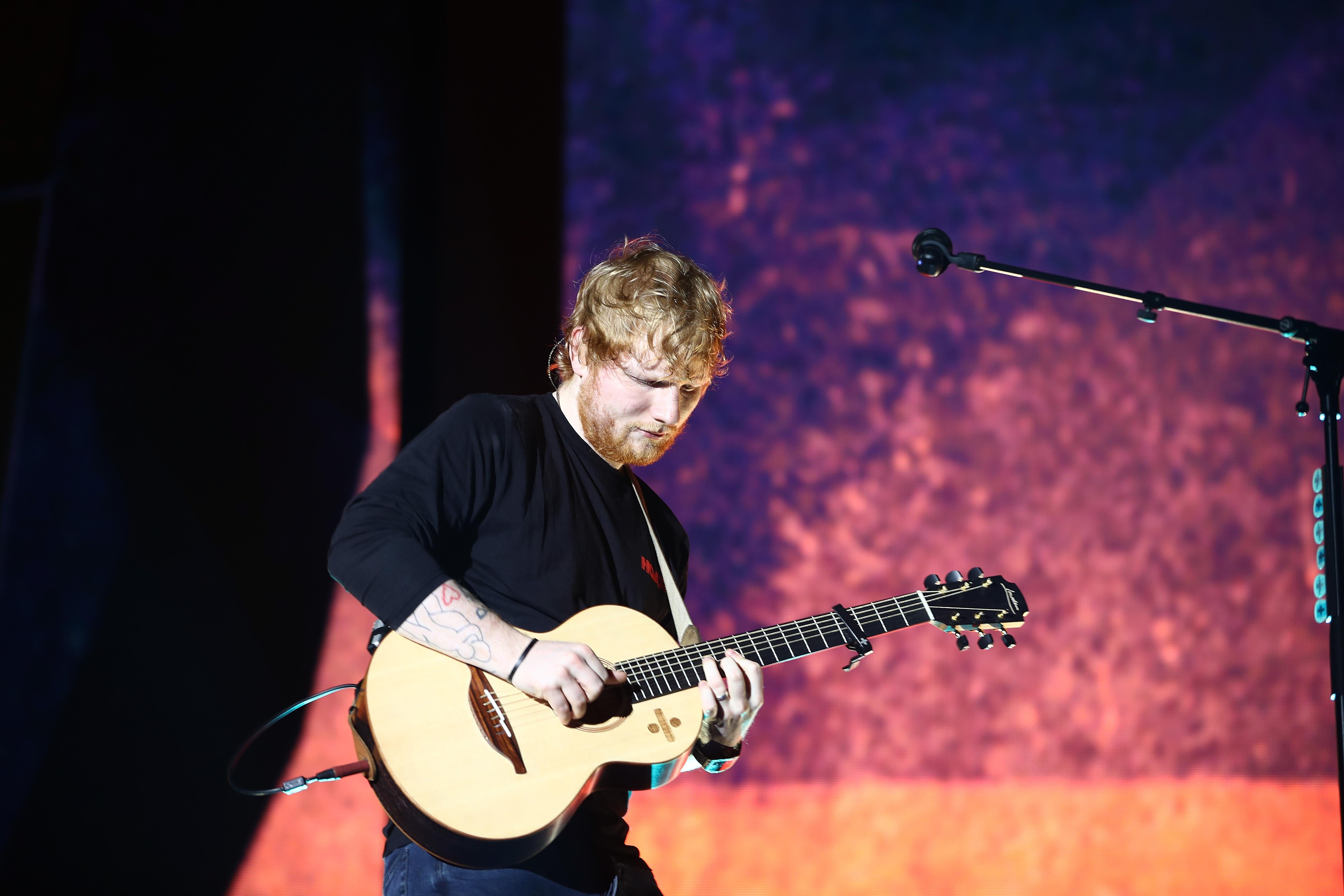 Ed Sheeran plays a guitar onstage in New Zealand