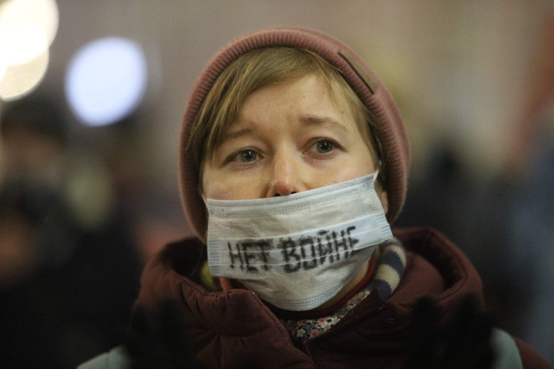 A woman wears a mask with Russian words written on it.