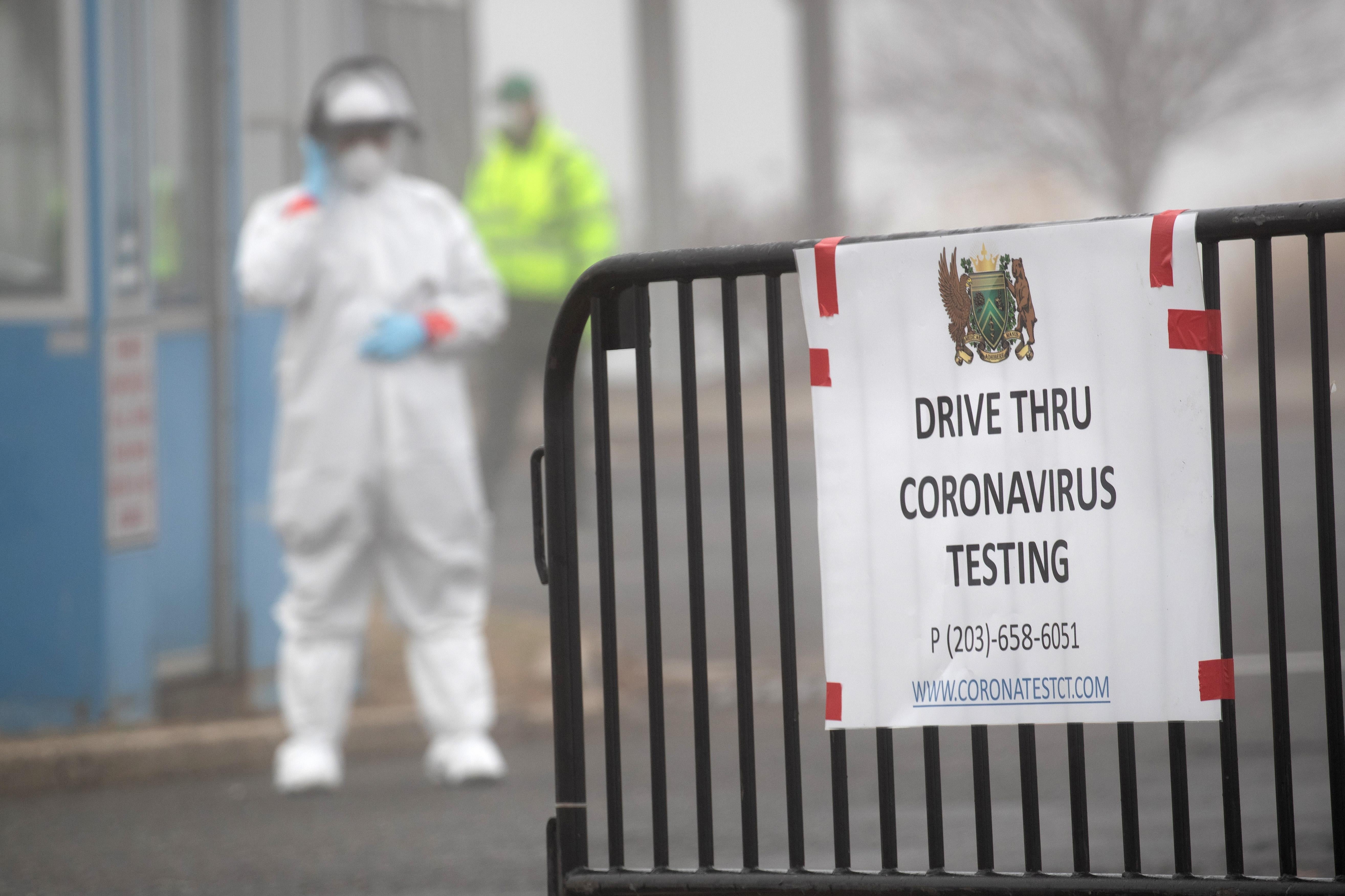 A sign sits on a barrier at a coronavirus (COVID-19) drive thru testing location operated by Murphy Medical Associates at Cummings Park on March 20, 2020 in Stamford, Connecticut.