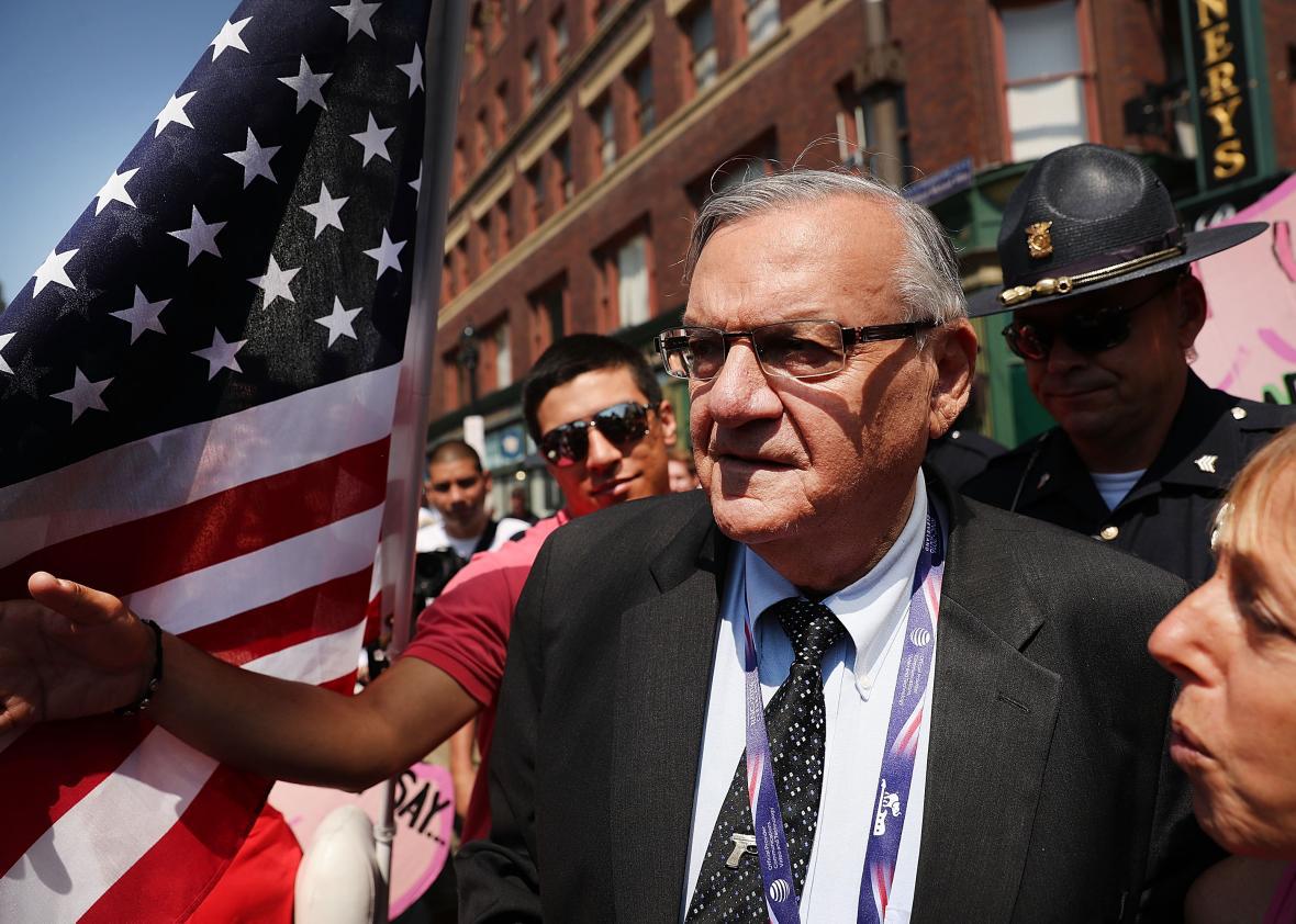 Arpaio in a crowd outside, next to an American flag.