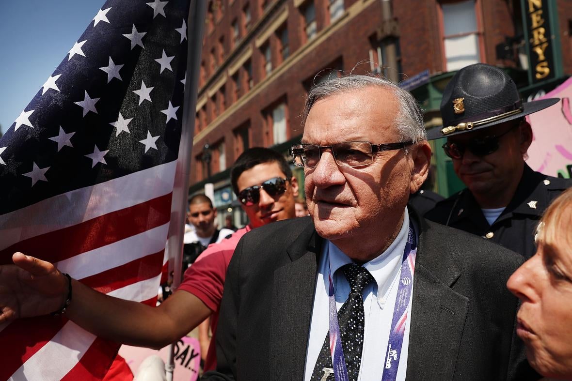Arpaio in a crowd outside, next to an American flag.