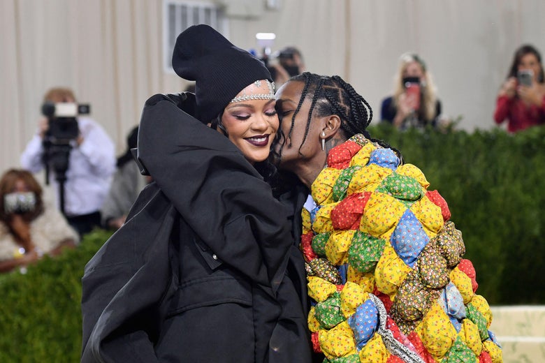 Rihanna smiles as ASAP Rocky kisses her cheek on the red carpet