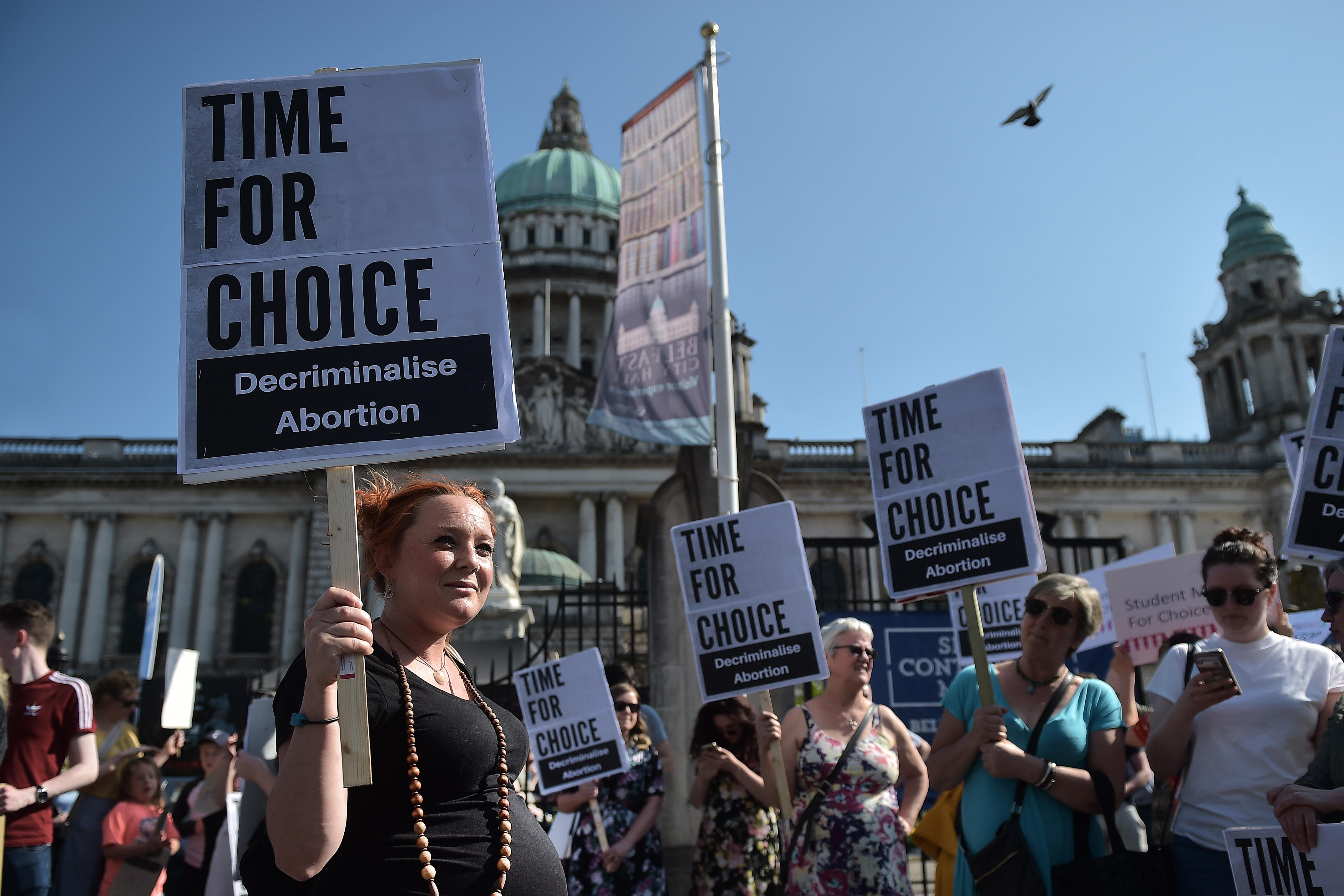 Protesters hold signs saying, "Time for Choice. Decriminalise Abortion."