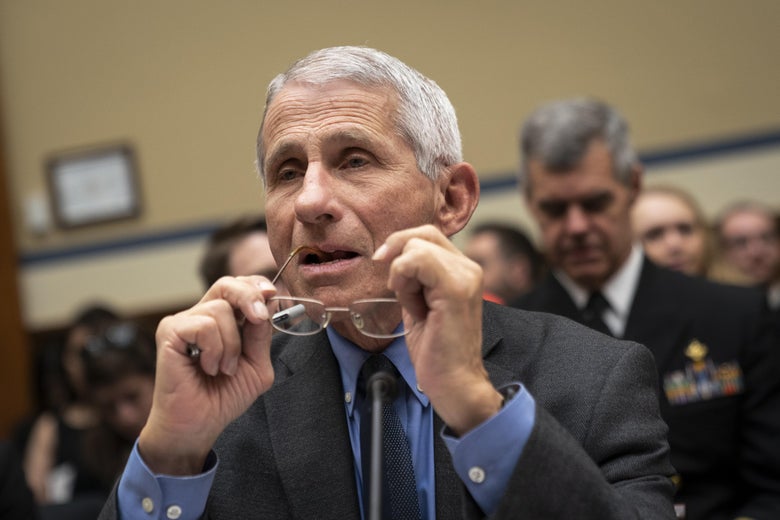 Fauci takes off his glasses as he speaks.