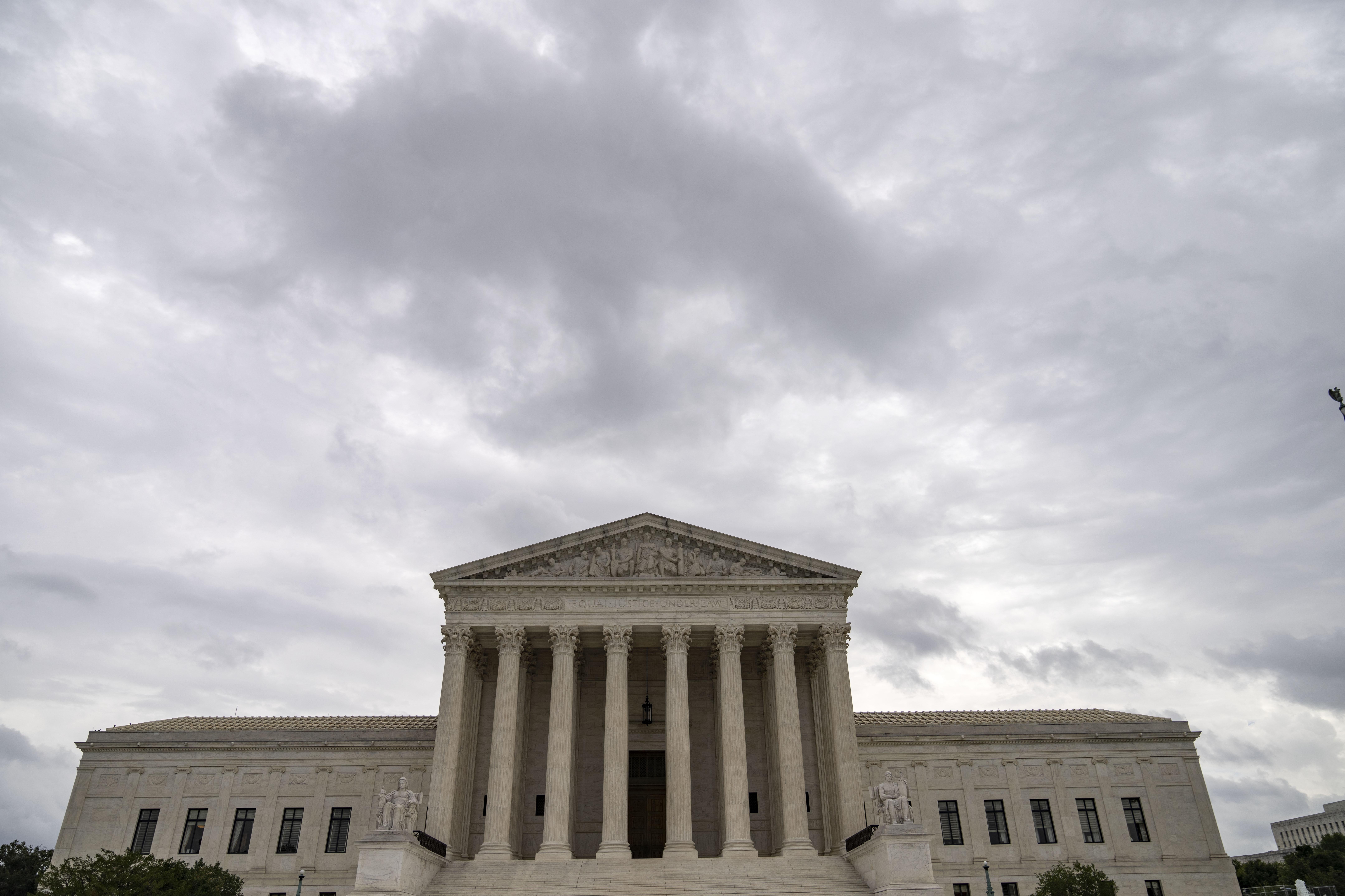 A photo of the Supreme Court from a low angle with an ominous sky.