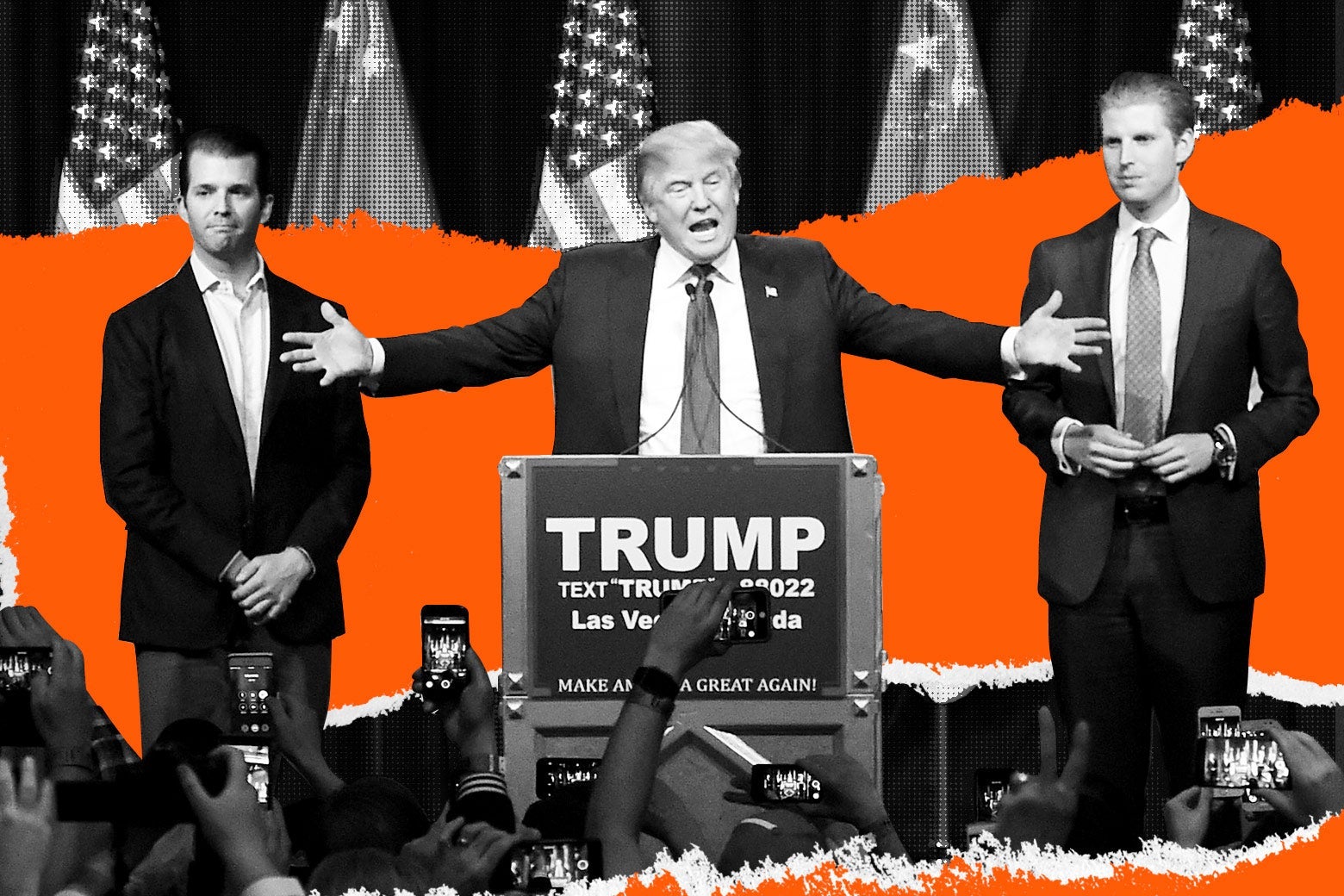 Donald Trump spreads his arms wide behind a podium that says TRUMP. His sons Donald Trump Jr. and Eric Trump stand beside him.