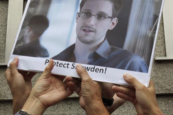Protesters supporting Edward Snowden, a contractor at the National Security Agency (NSA), hold a photo of Snowden during a demonstration outside the U.S. Consulate in Hong Kong June 13, 2013.