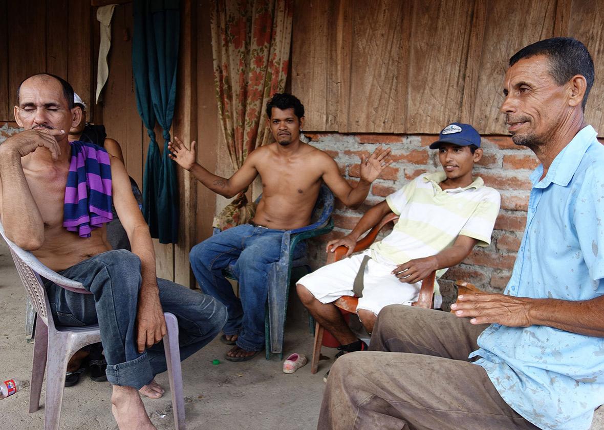 Four papaya farmers discussing the canal over a bottle of rum.