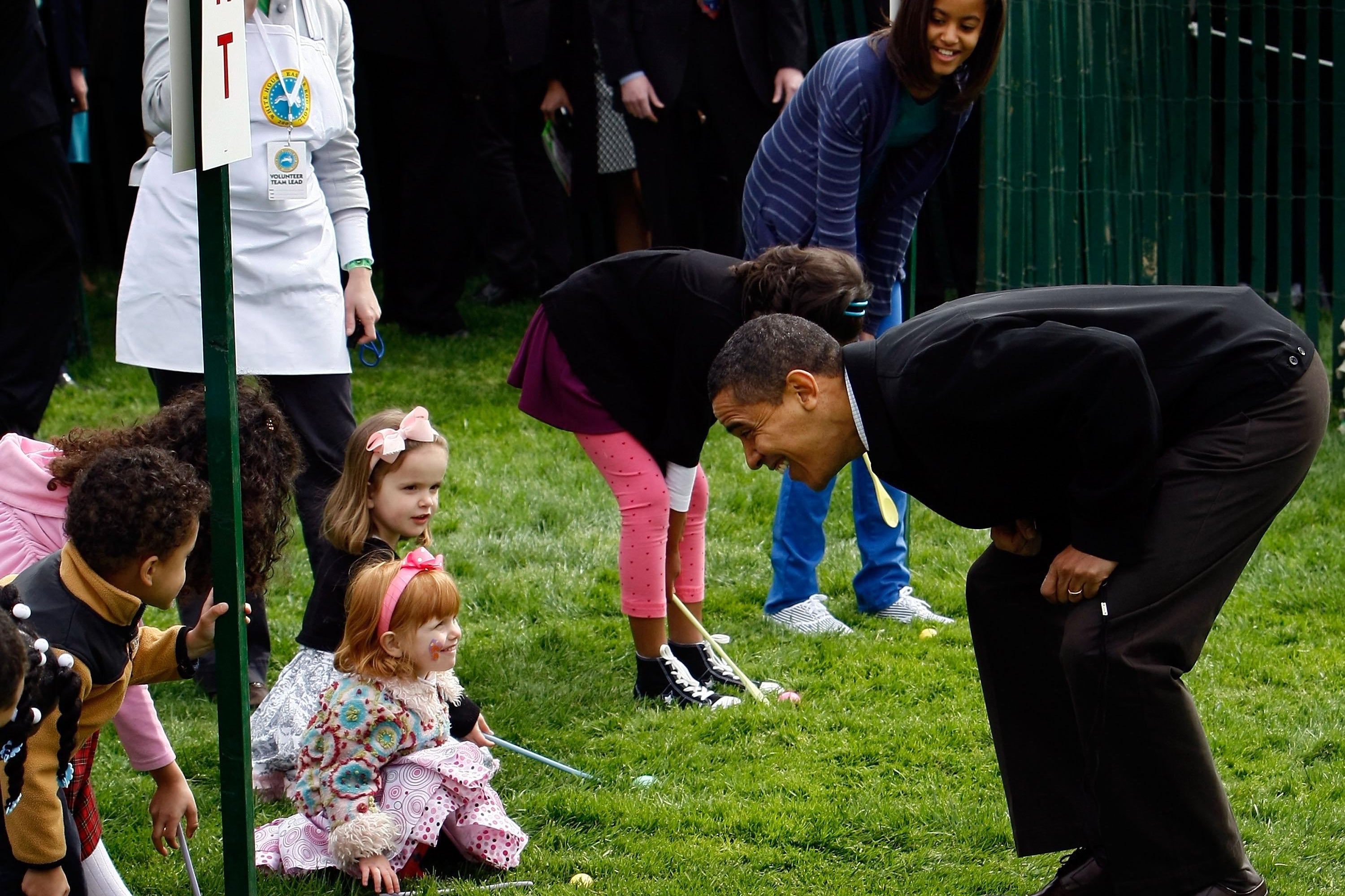 Obama leans down to talk to children competing in an Easter egg roll.