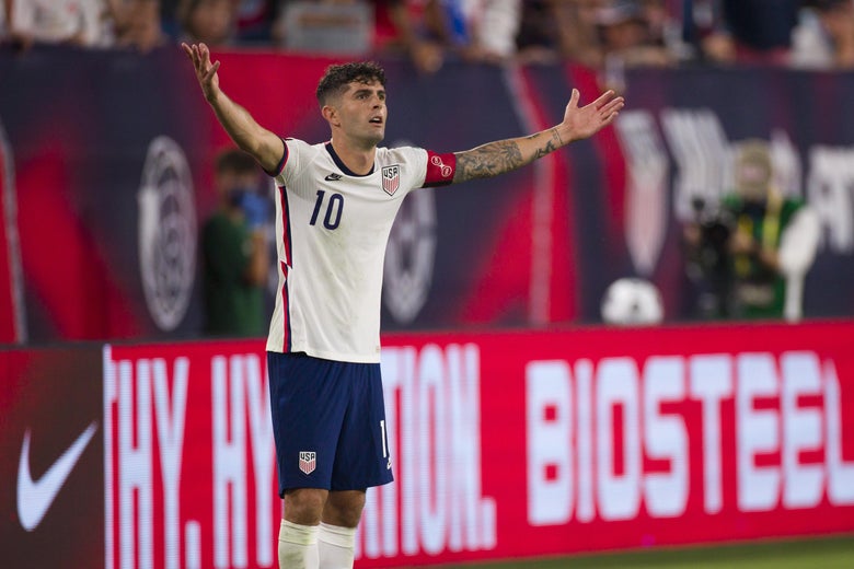 Christian Pulisic stretches his arms out wide to protest a referee's decision.