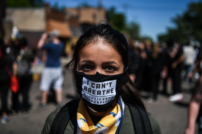 A woman poses as she wears a mask at the makeshift memorial in honor of George Floyd, who died while in custody of the Minneapolis police, following a day of demonstration in a call for justice on May 30, 2020 in Minneapolis, Minnesota. 