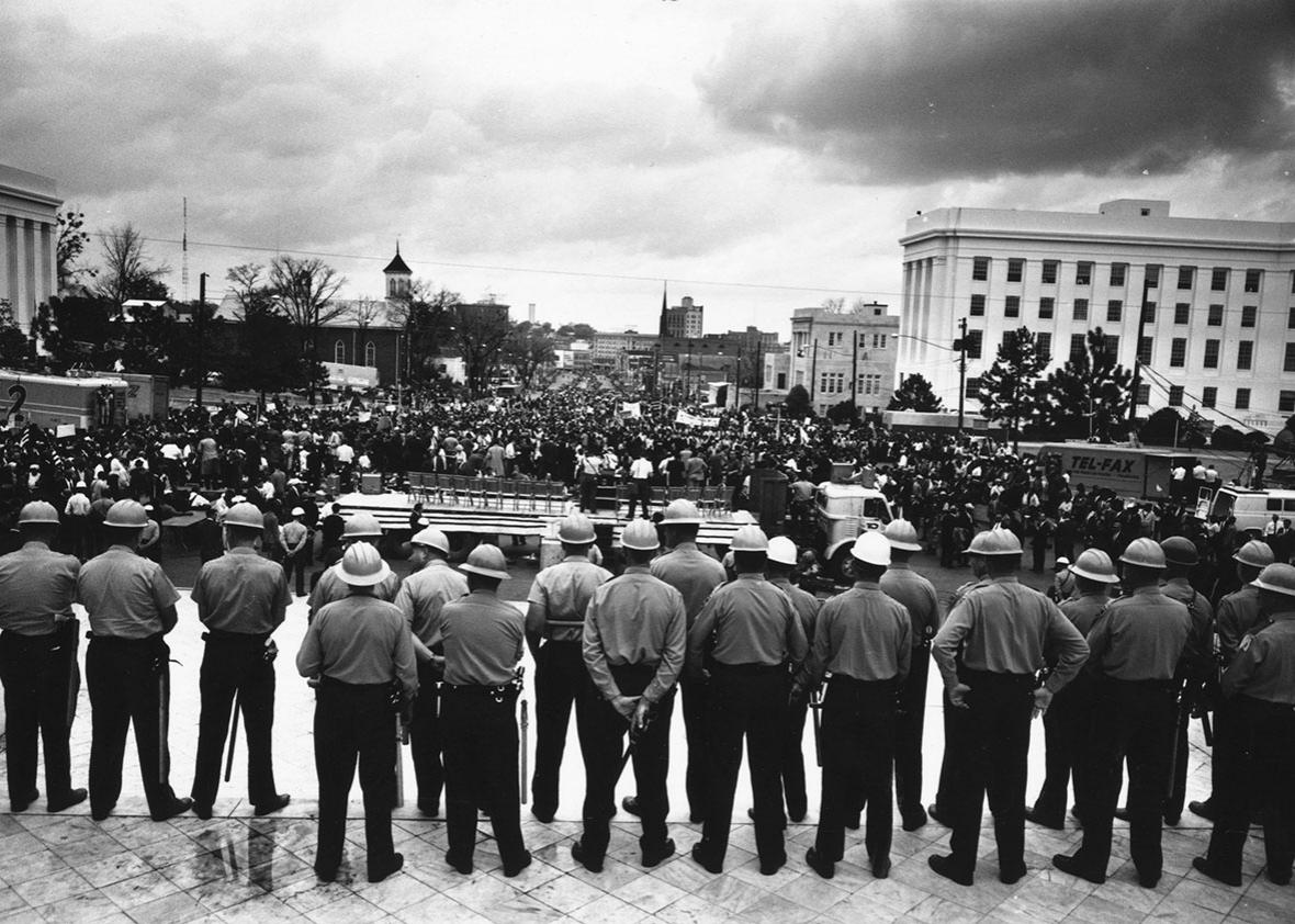 A line of policemen on duty during a black voting rights march i