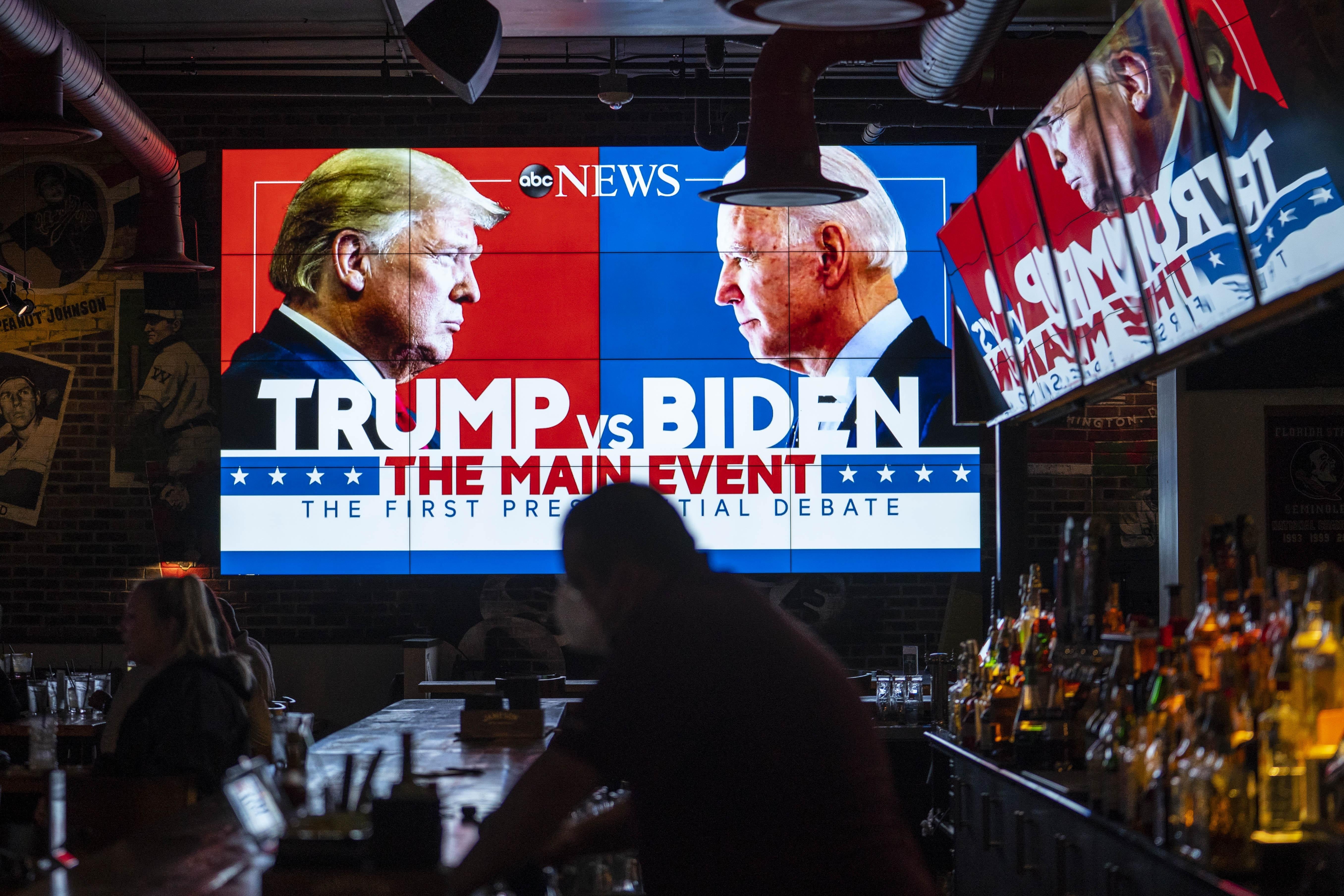 A giant TV screen in a bar promotes the first "Trump vs. Biden" presidential debate.