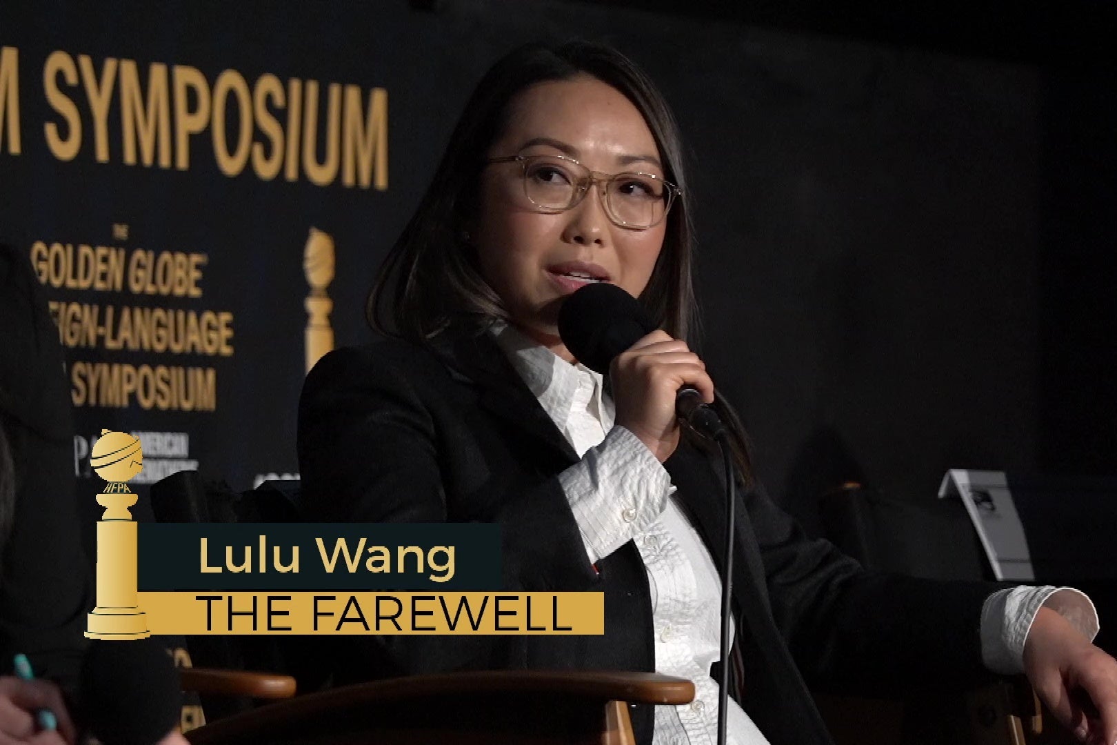 Lulu Wang sitting in a director's chair answering questions on stage at the Egyptian Theatre.