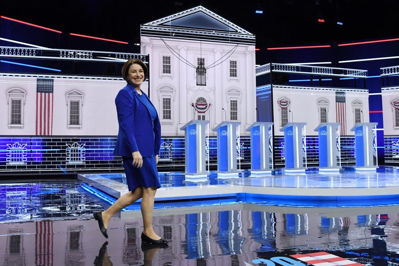 Amy Klobuchar walks across the debate stage.