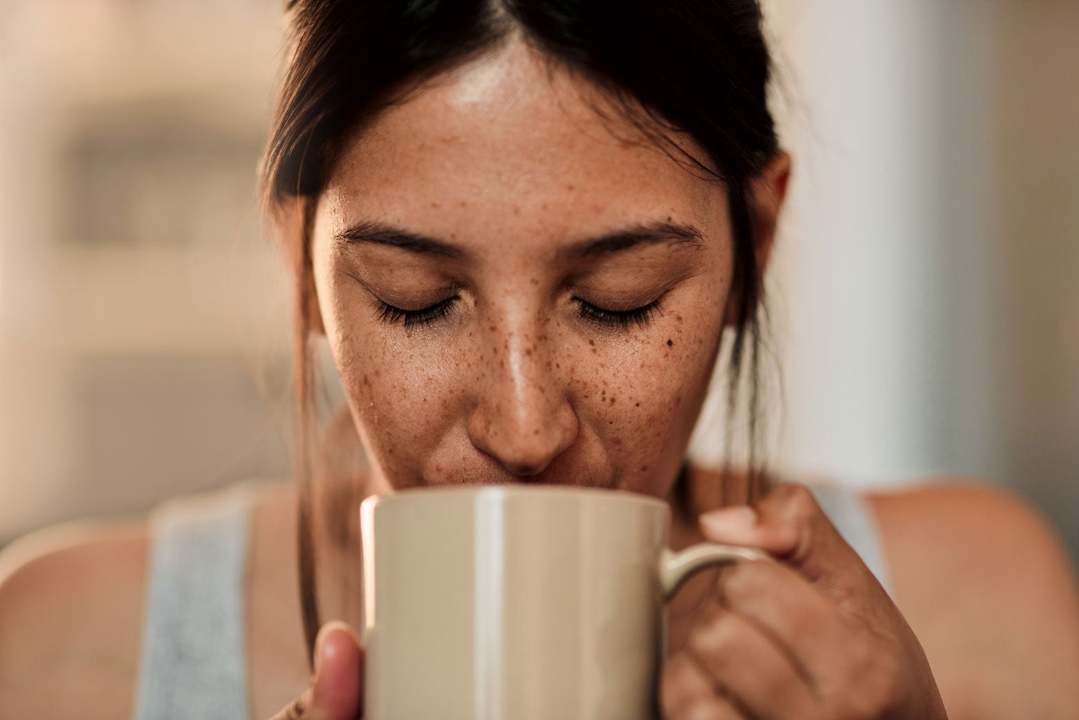 A woman drinking a cup of coffee.