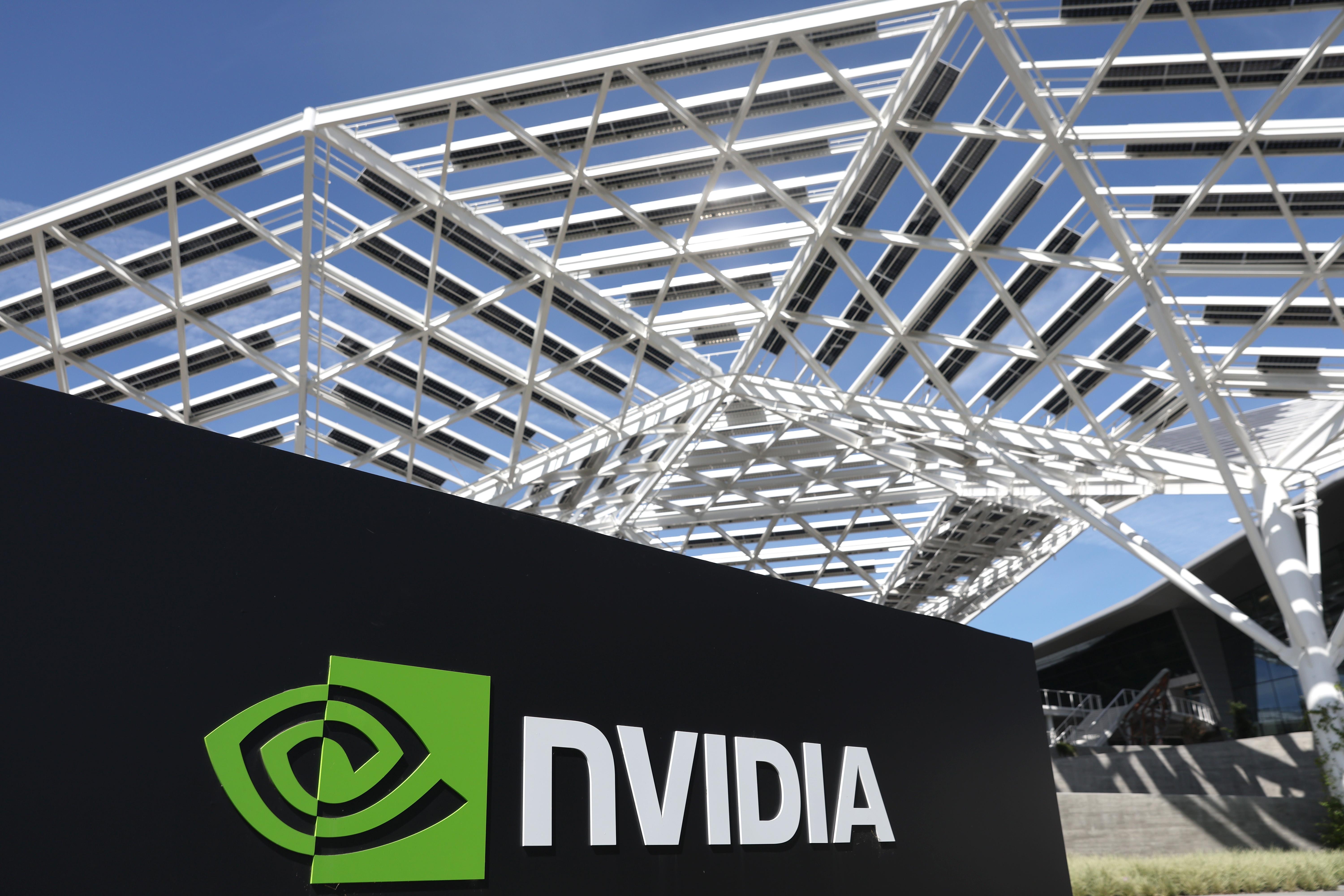 A black sign at the Nvidia headquarters, which says the company name in white and shows the company logo, a green swirl in the shape of an eye. 