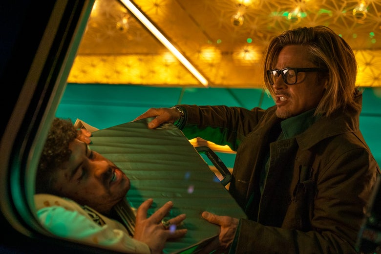 A shot through a train window shows Pitt, clothed in a rain jacket and glasses with thick black frames, his long hair flowing behind him, shoving a briefcase into Bad Bunny’s throat.