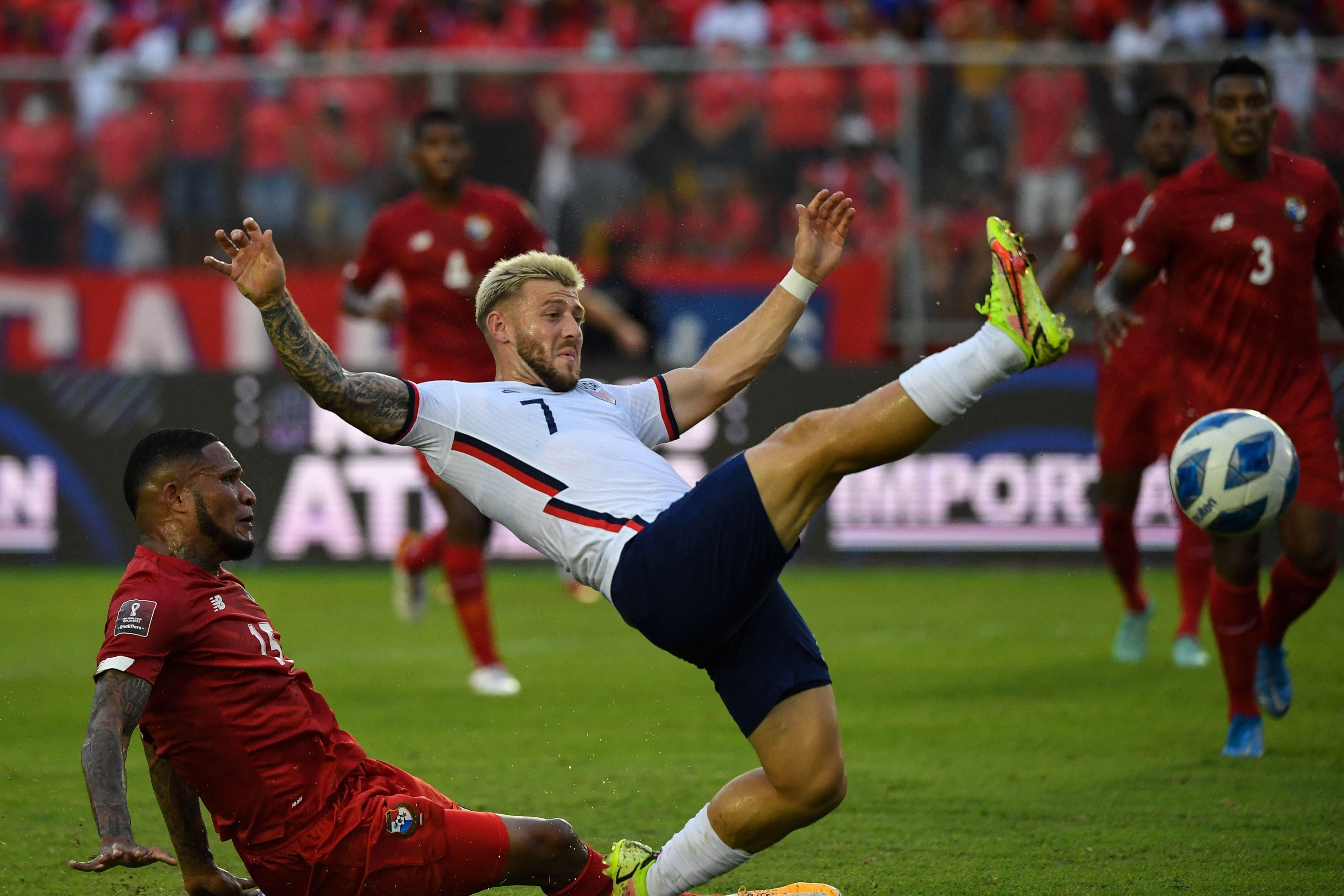 U.S. soccer player Paul Arriola kicks his leg up high as he slips and falls.